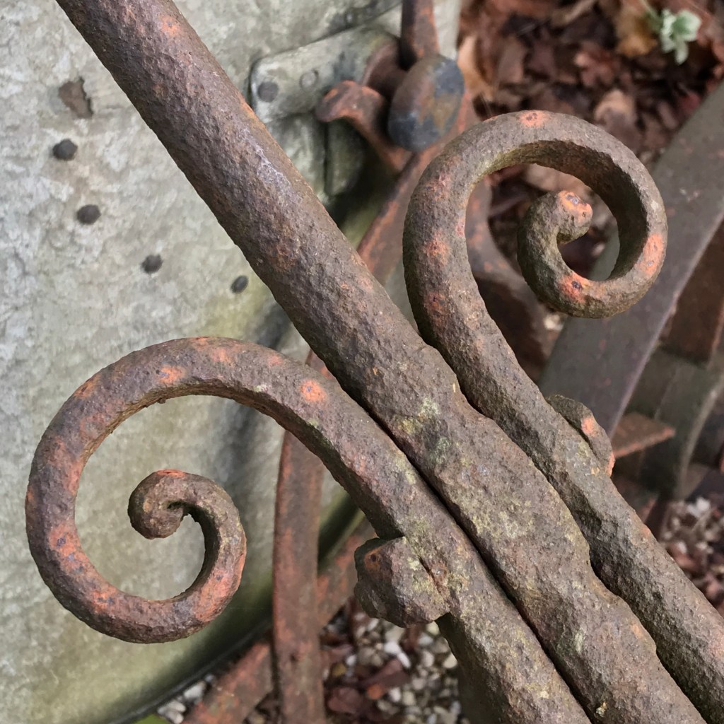 An ironwork scroll on a very old garden roller